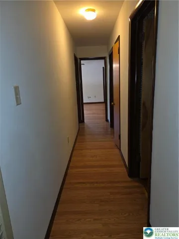 a view of a hallway with wooden floor