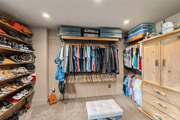 a view of walk in closet with clothes and shoes