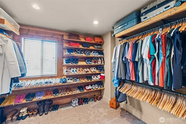 a view of walk in closet with clothes and shoes