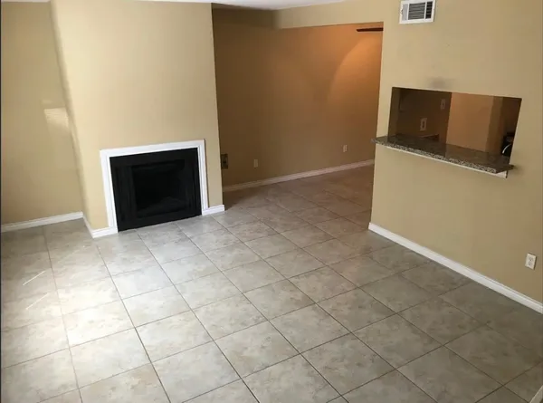 a view of an empty room with wooden floor and cabinet