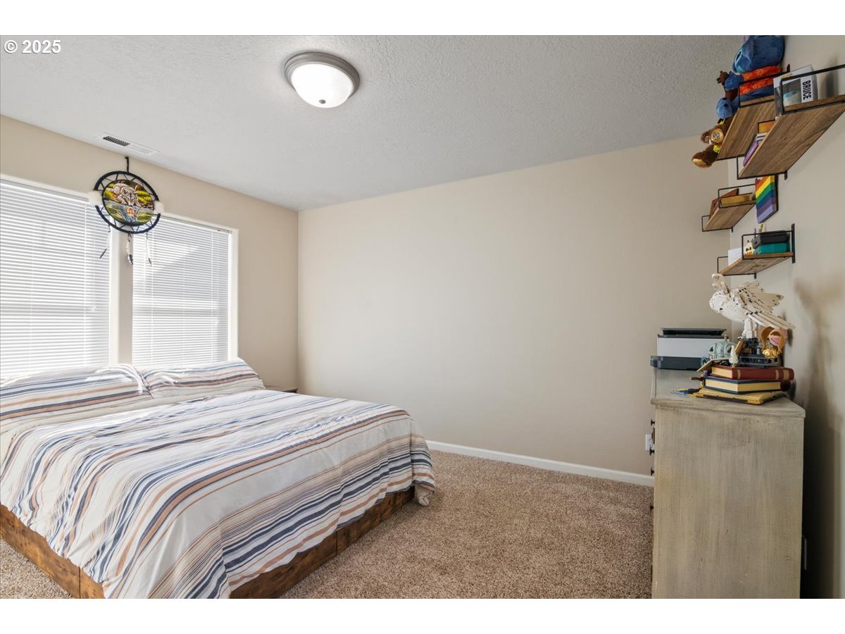 4135 Geranium Loop Northeast Salem, OR 97305 - Photo 11 of 18 a bedroom with a bed and a window
