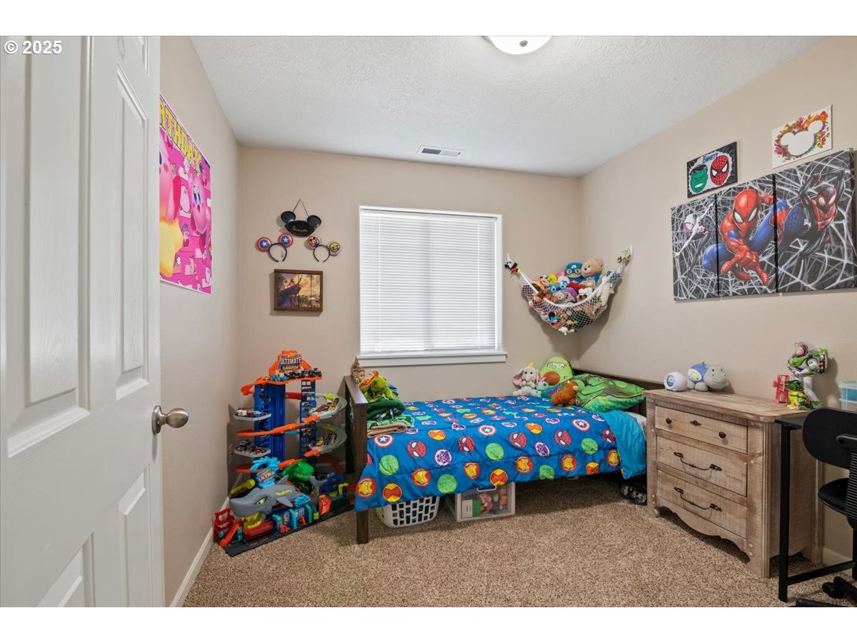 4135 Geranium Loop Northeast Salem, OR 97305 - Photo 15 of 18 a bedroom with a bed a baby and a dresser