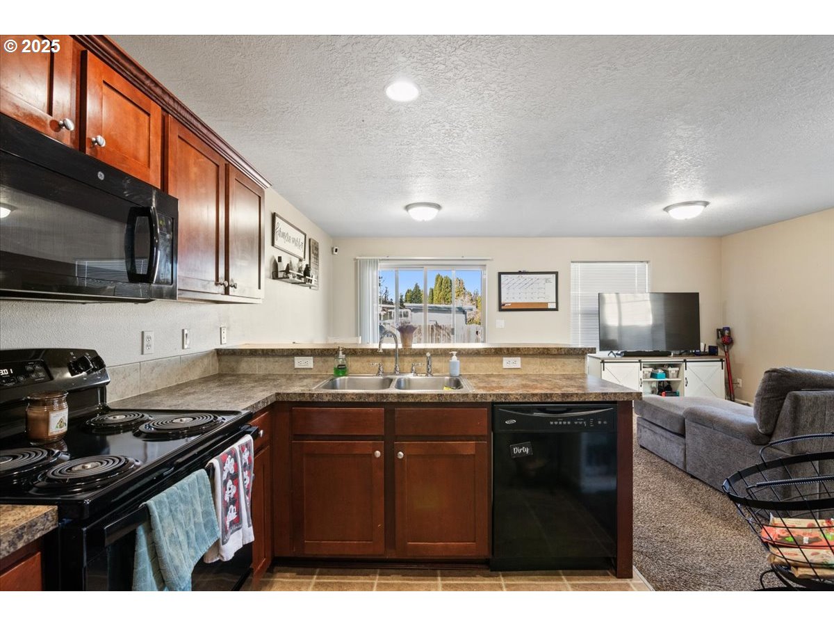 4135 Geranium Loop Northeast Salem, OR 97305 - Photo 7 of 18 a kitchen with granite countertop a sink a stove a oven a window cabinets and a dining table