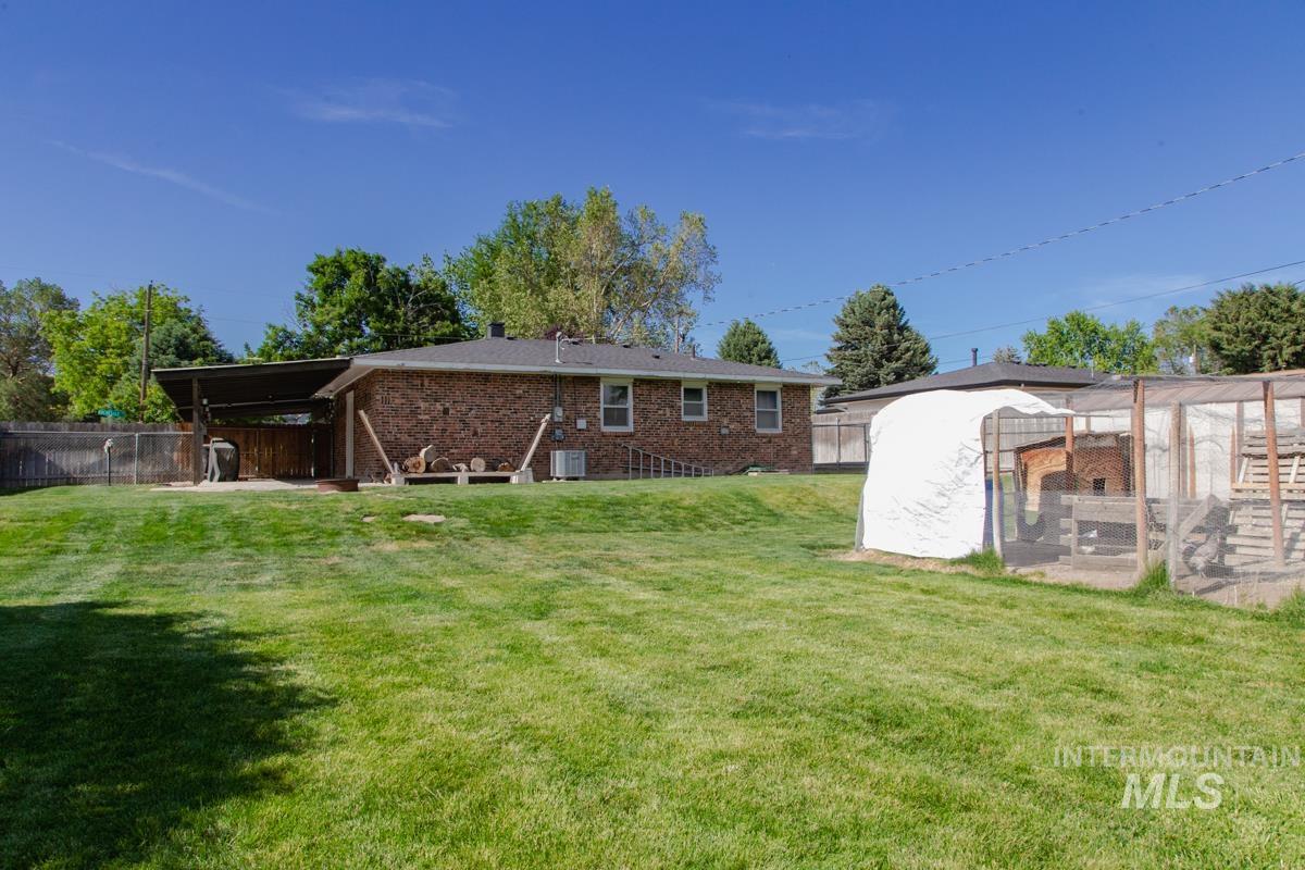 1404 Rochester Street Caldwell, ID 83605 - Photo 27 of 29 Expansive green lawn with a brick exterior structure and a covered patio area