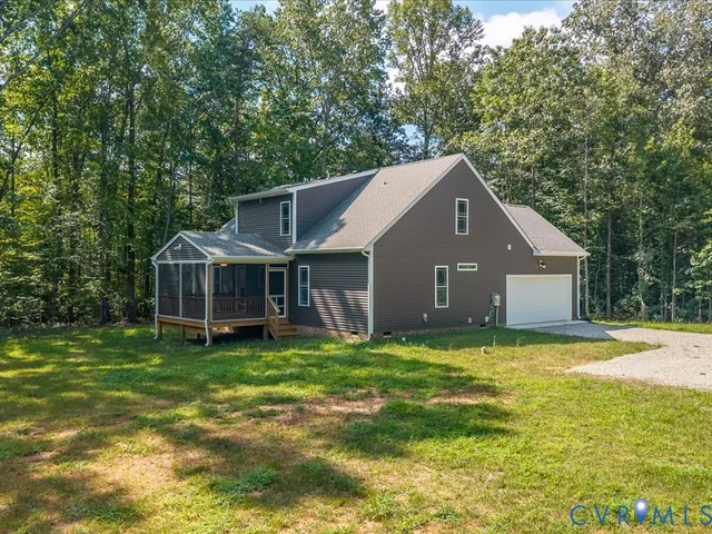 a house that is sitting in the grass with large trees