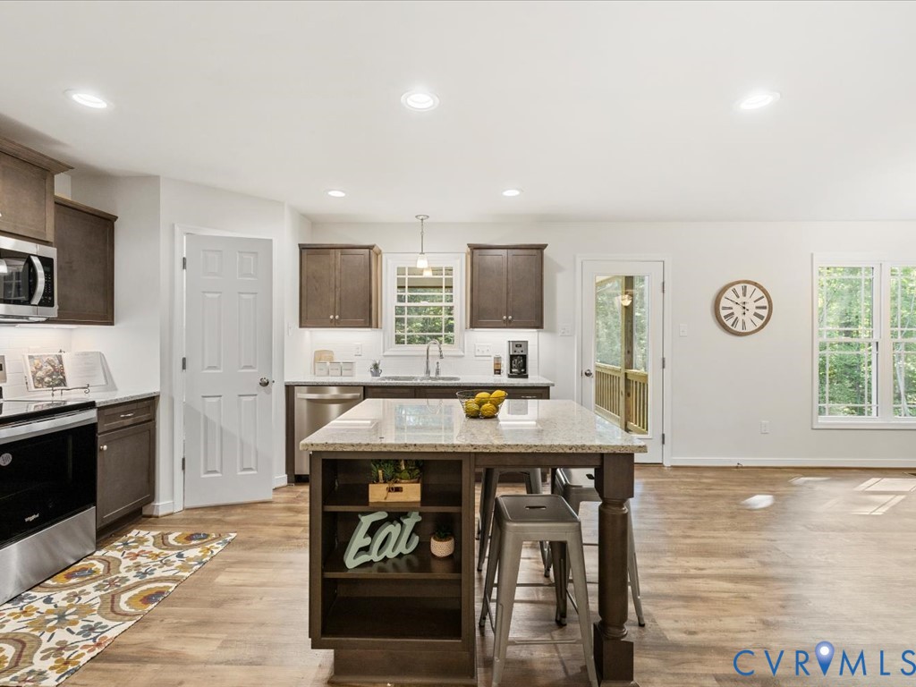 1146 Clayton Road Powhatan, VA 23139 - Photo 7 of 42 a kitchen with stainless steel appliances granite countertop a stove top oven a sink dishwasher and a refrigerator with wooden floor