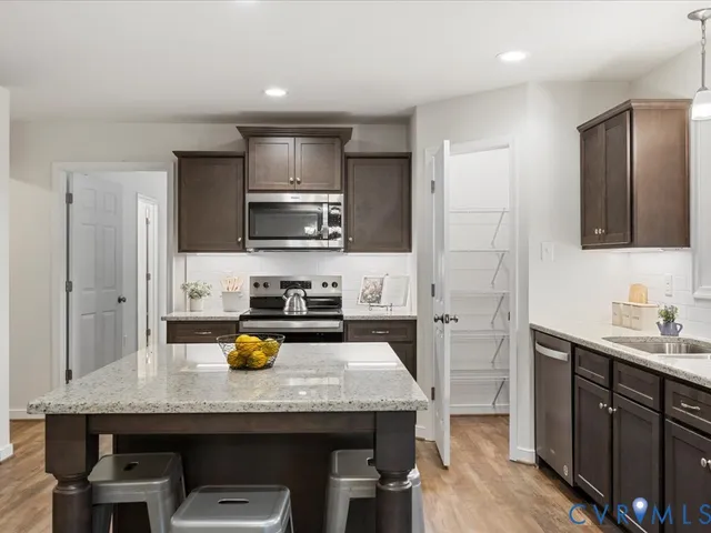 a kitchen with a sink a counter space appliances and cabinets