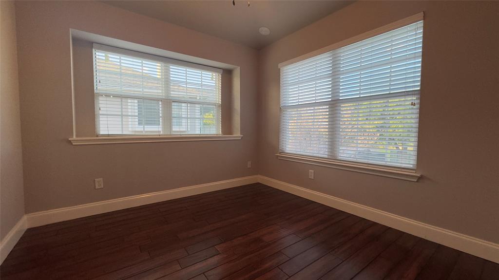 1900 Scofield Ridge Parkway, Unit 5501 Austin, TX 78727 - Photo 9 of 21 Dark wood flooring flows through this comfortable room, illuminated by natural light from two large windows.