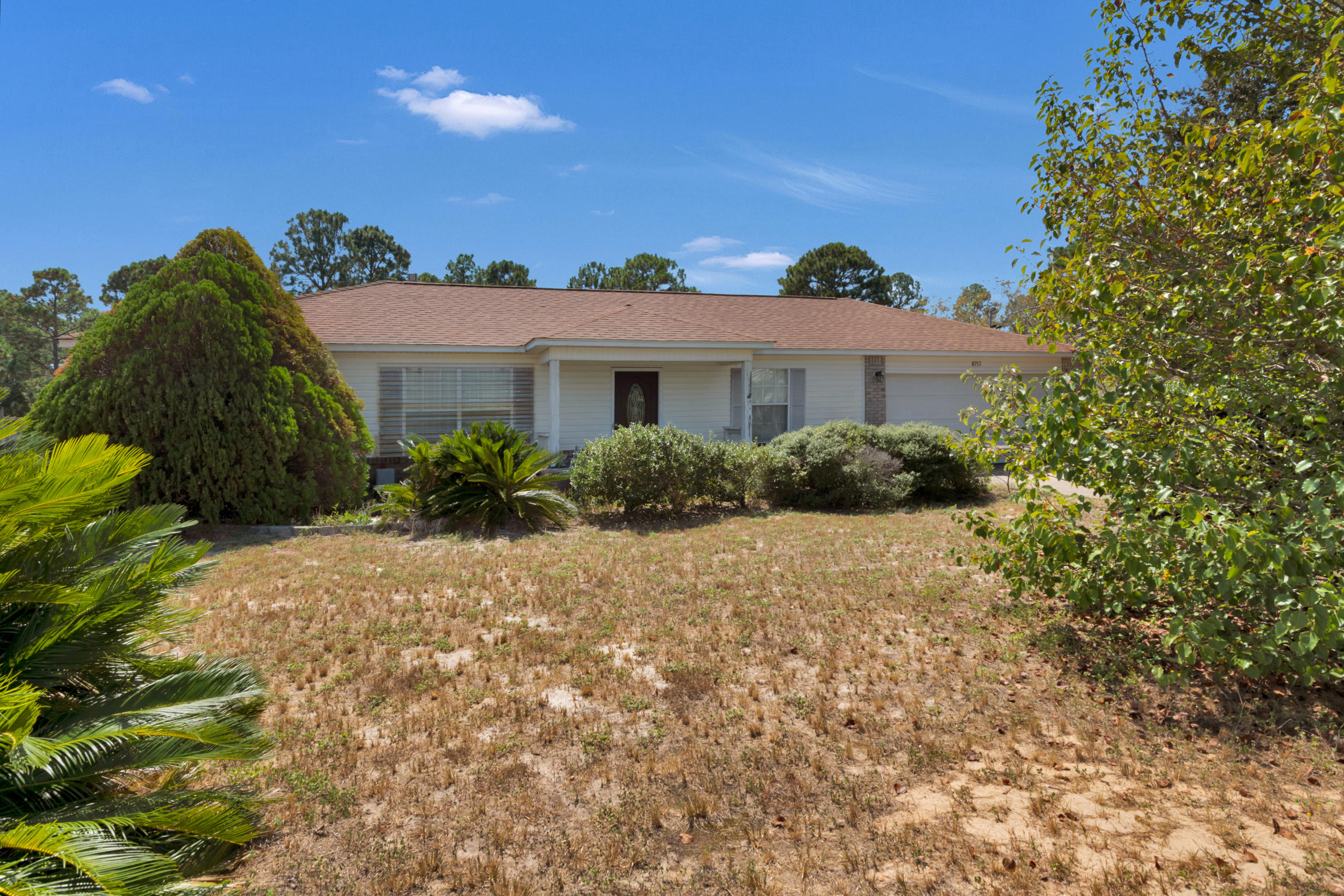 8757 Laredo Street Navarre, FL 32566 - Photo 1 of 14 a view of a house with a yard and potted plants