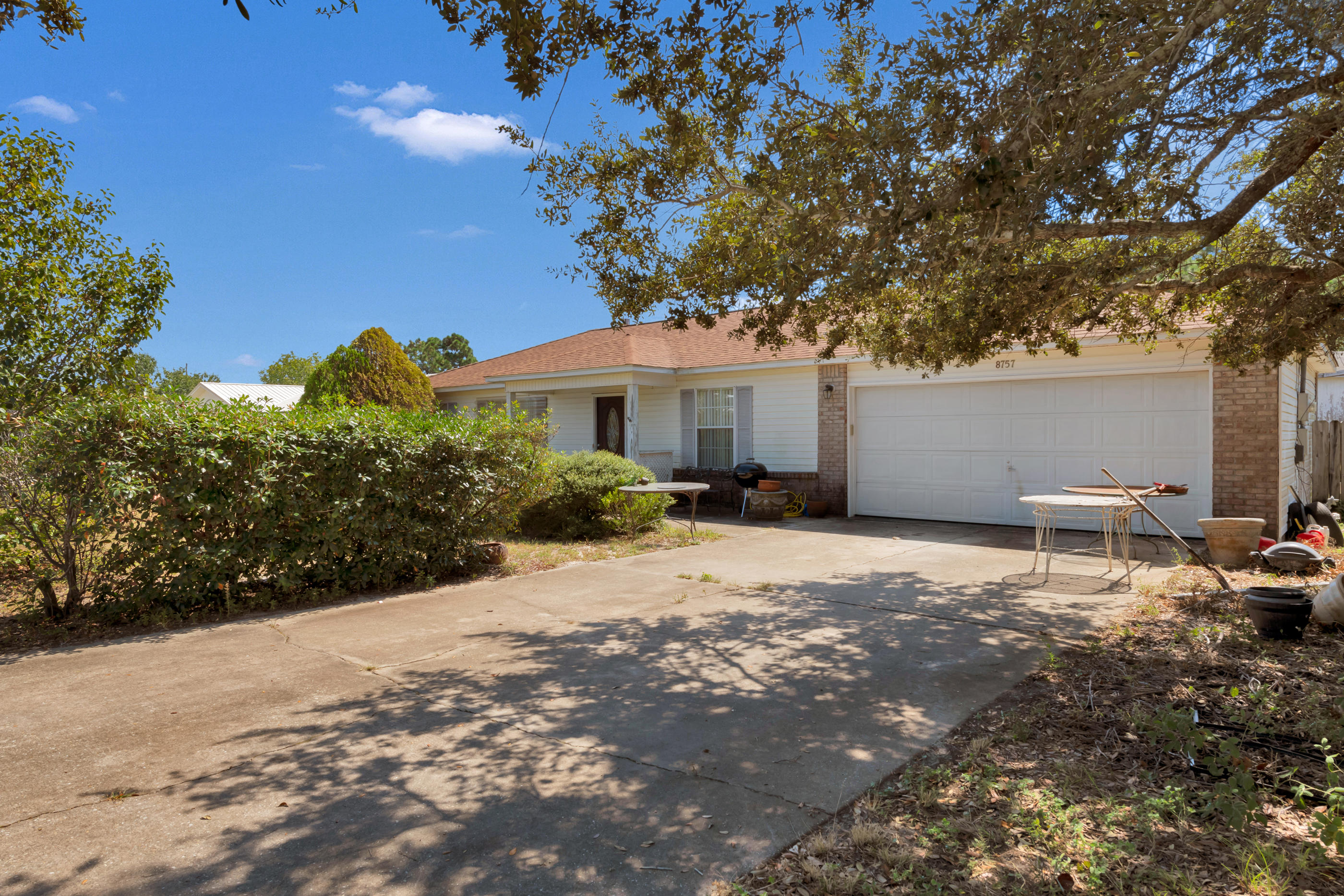 8757 Laredo Street Navarre, FL 32566 - Photo 2 of 14 a house with trees in front of it