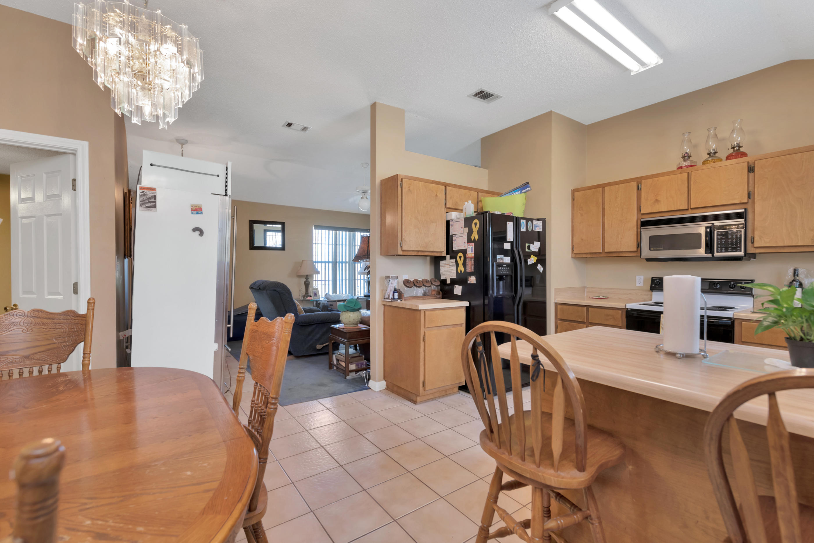8757 Laredo Street Navarre, FL 32566 - Photo 4 of 14 a kitchen with stainless steel appliances granite countertop a dining table and chairs