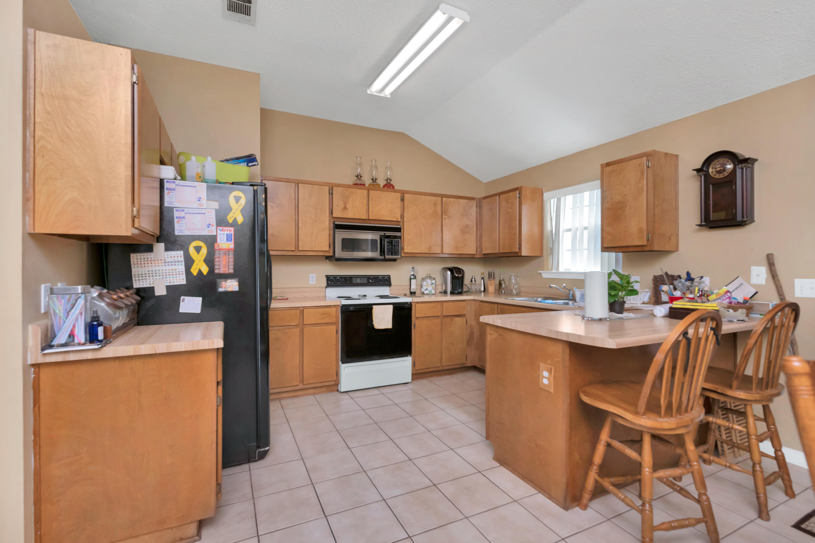 8757 Laredo Street Navarre, FL 32566 - Photo 5 of 14 a kitchen with stainless steel appliances kitchen island granite countertop a sink and cabinets