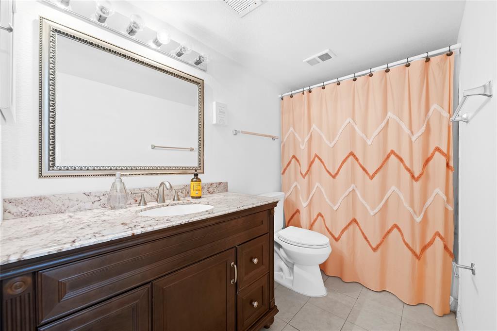 2736 South University Drive, Unit 1204 Davie, FL 33328 - Photo 11 of 23 a bathroom with a granite countertop sink a toilet and a mirror