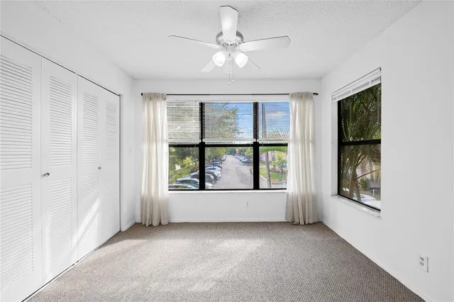 an empty room with windows and cabinet