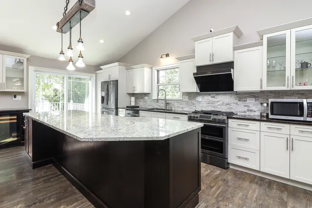 a kitchen with stainless steel appliances granite countertop a sink stove and refrigerator