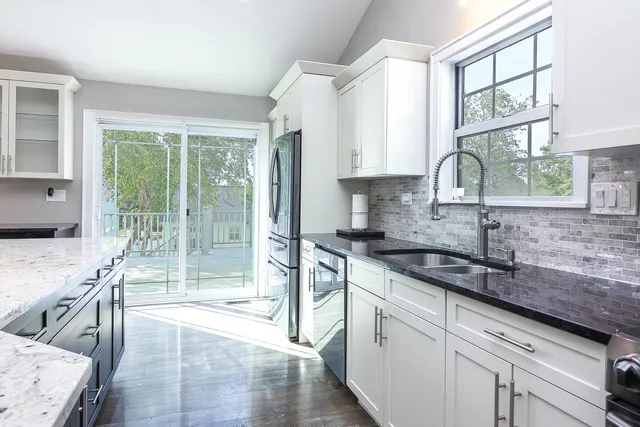 a kitchen with a large window a sink and cabinets