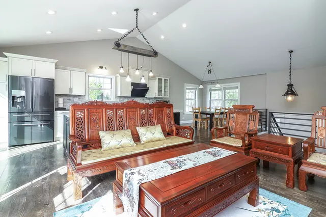 a living room with furniture a flat screen tv and kitchen view