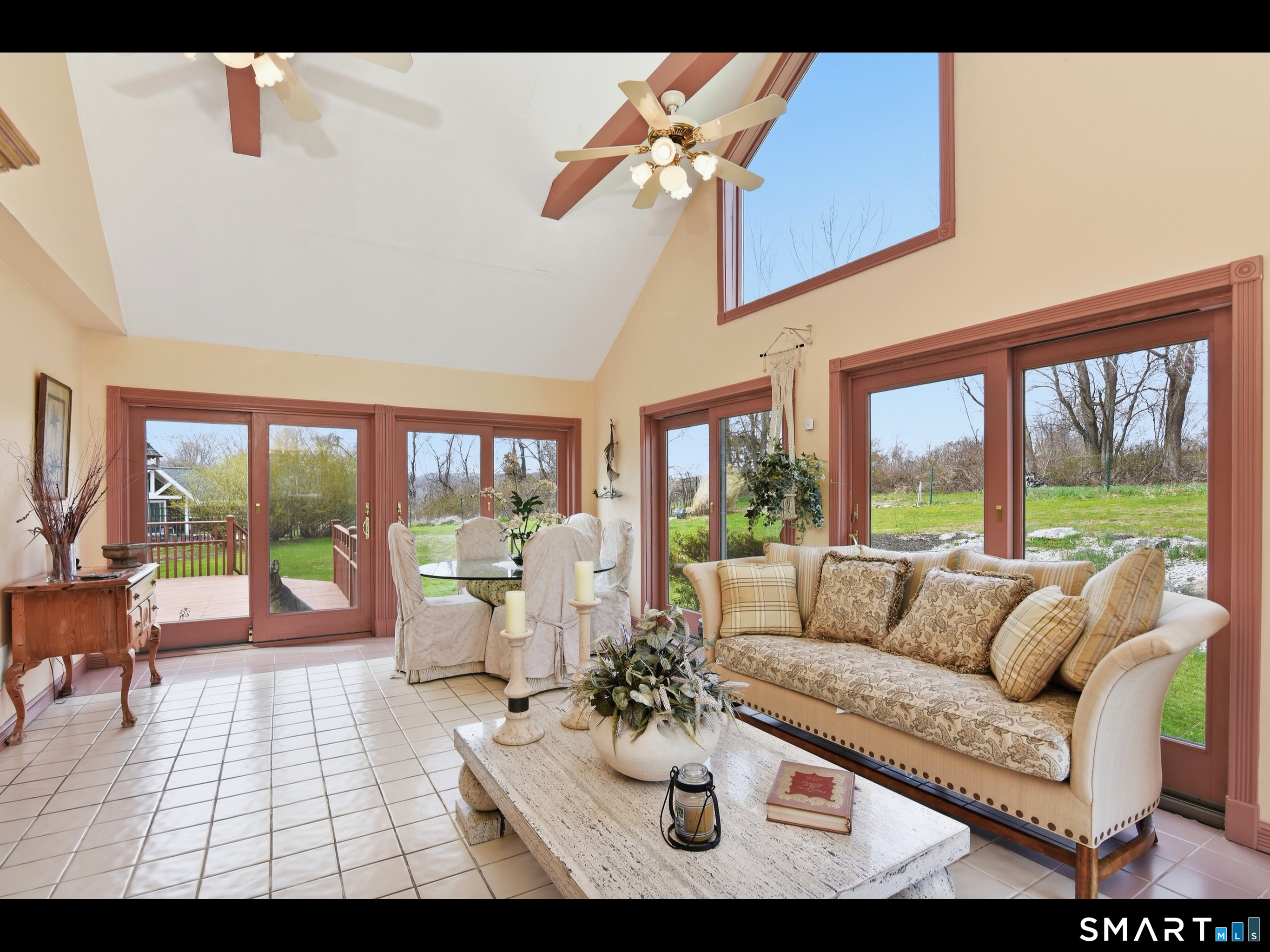 33 Meehan Road Woodstock, CT 06281 - Photo 12 of 39 Spacious sunroom offers a cathedral ceiling with exposed beam detail and panoramic outdoor views through 6 sets of sliding glass doors.