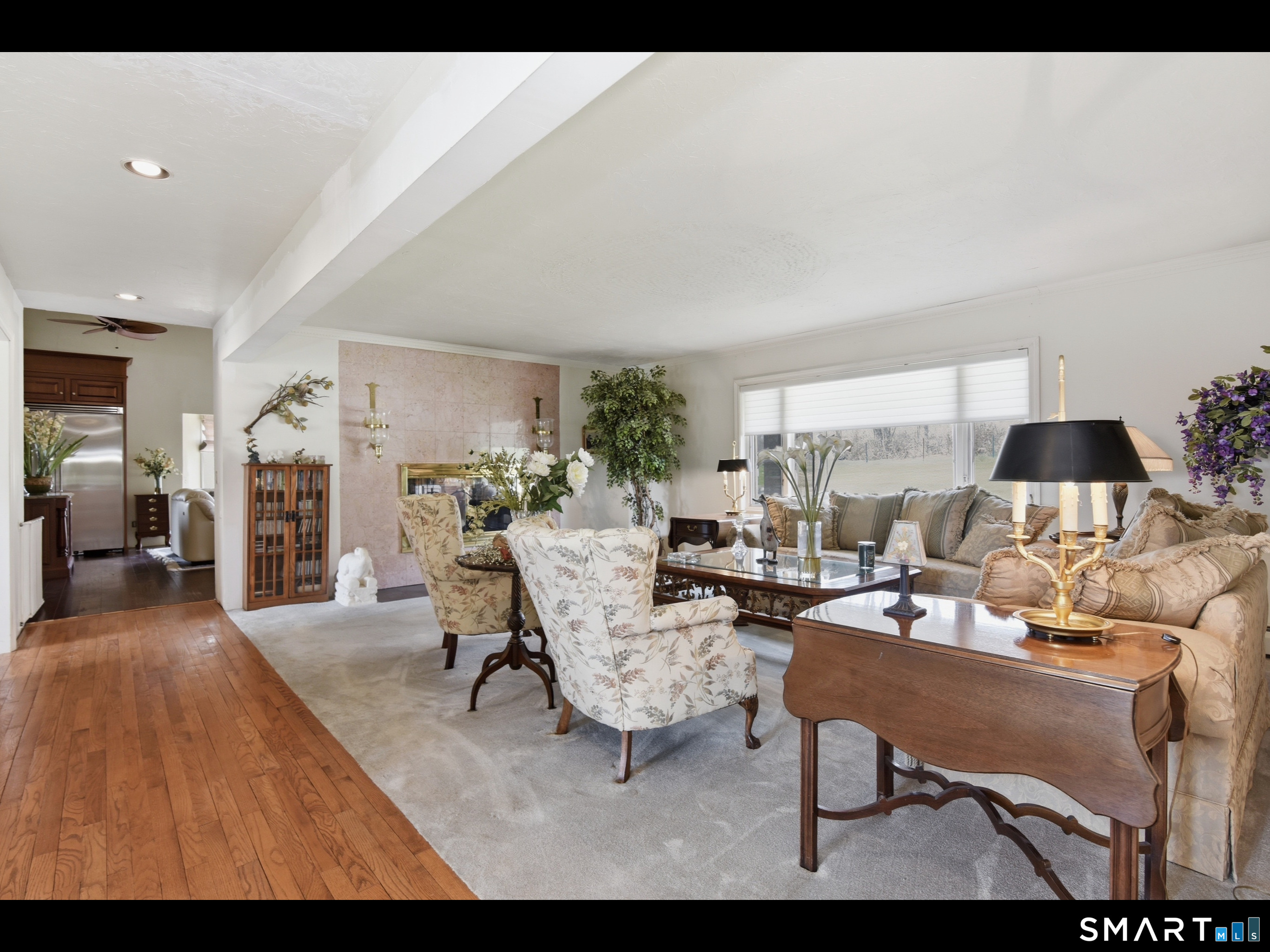 33 Meehan Road Woodstock, CT 06281 - Photo 13 of 39 The formal living room features expansive windows and is anchored by the double-sided fireplace, accented by substantial wall sconces.