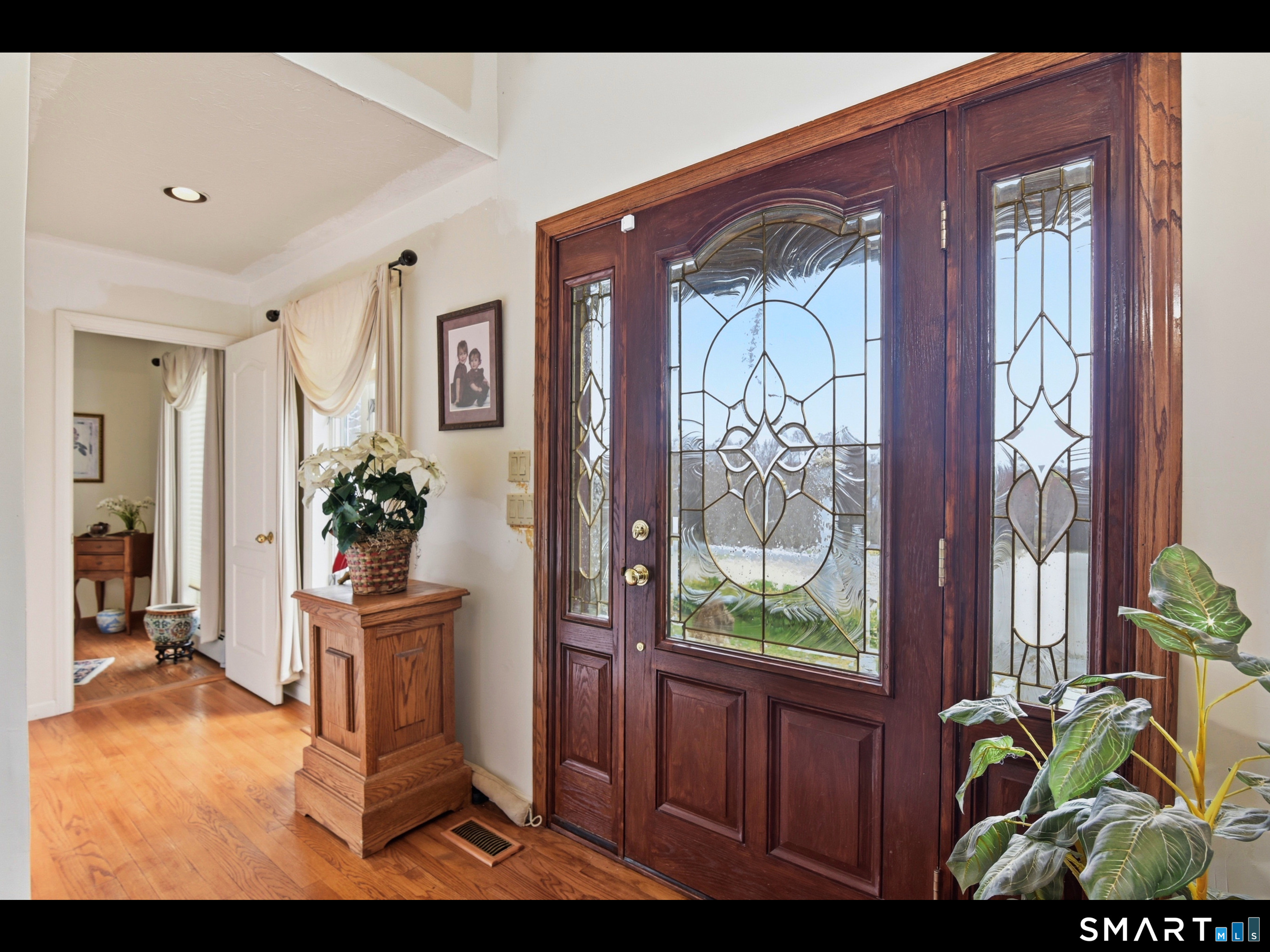 33 Meehan Road Woodstock, CT 06281 - Photo 14 of 39 The foyer boasts a rich wood entry door with elegant leaded-glass detailing, complemented by hardwood flooring. A thoughtfully placed half bath is situated just off the entrance.