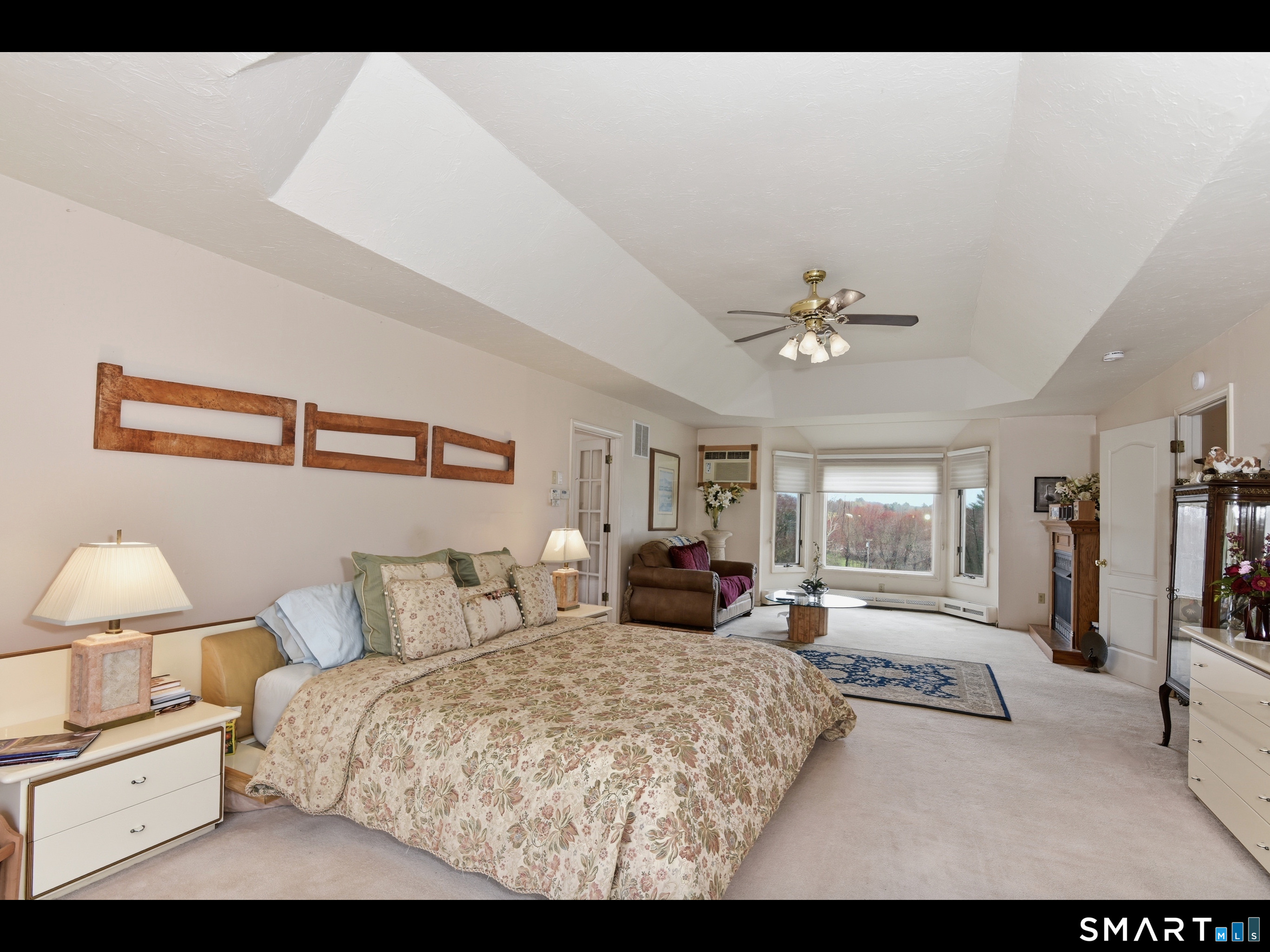 33 Meehan Road Woodstock, CT 06281 - Photo 16 of 39 Sprawling primary bedroom features a tray ceiling, a bay-style window alcove, and well-proportioned seating area.
