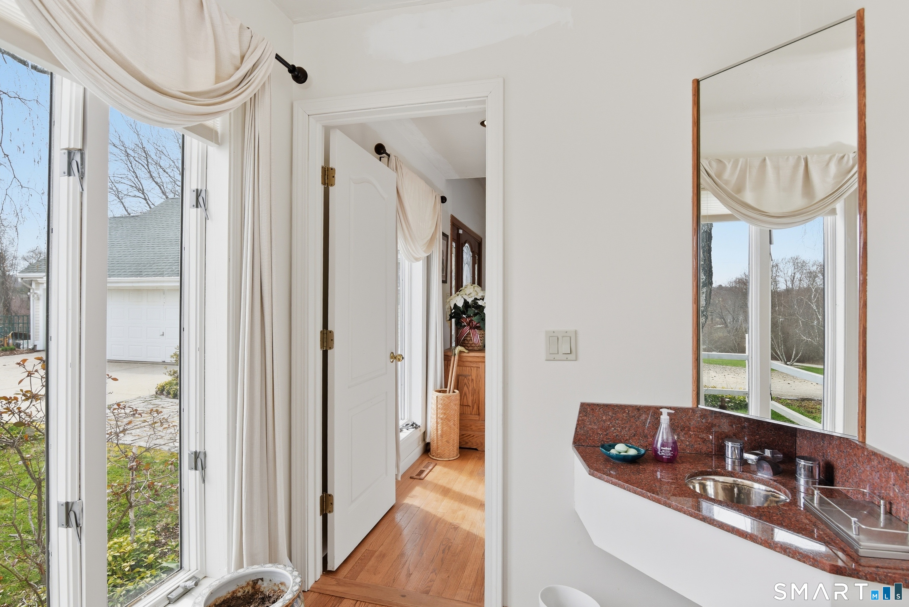 33 Meehan Road Woodstock, CT 06281 - Photo 18 of 39 The stylish half bath, adjacent to the foyer, is appointed with a polished granite vanity, vessel-style sink, natural light, and hardwood flooring,