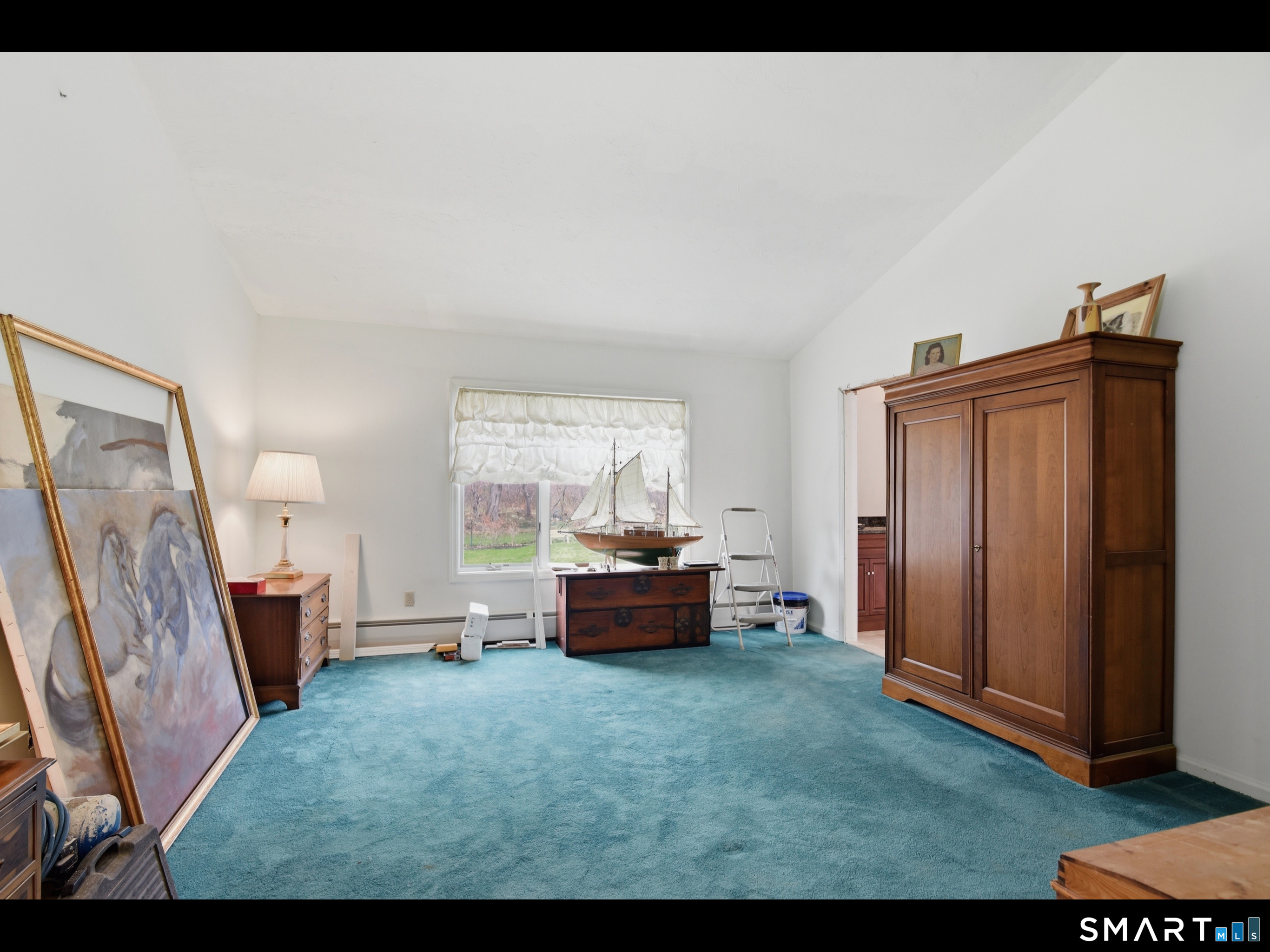33 Meehan Road Woodstock, CT 06281 - Photo 21 of 39 Bedroom 3, on the upper level, is characterized by a high vaulted ceiling, access to a floored walk-in attic space, and peaceful nature views.