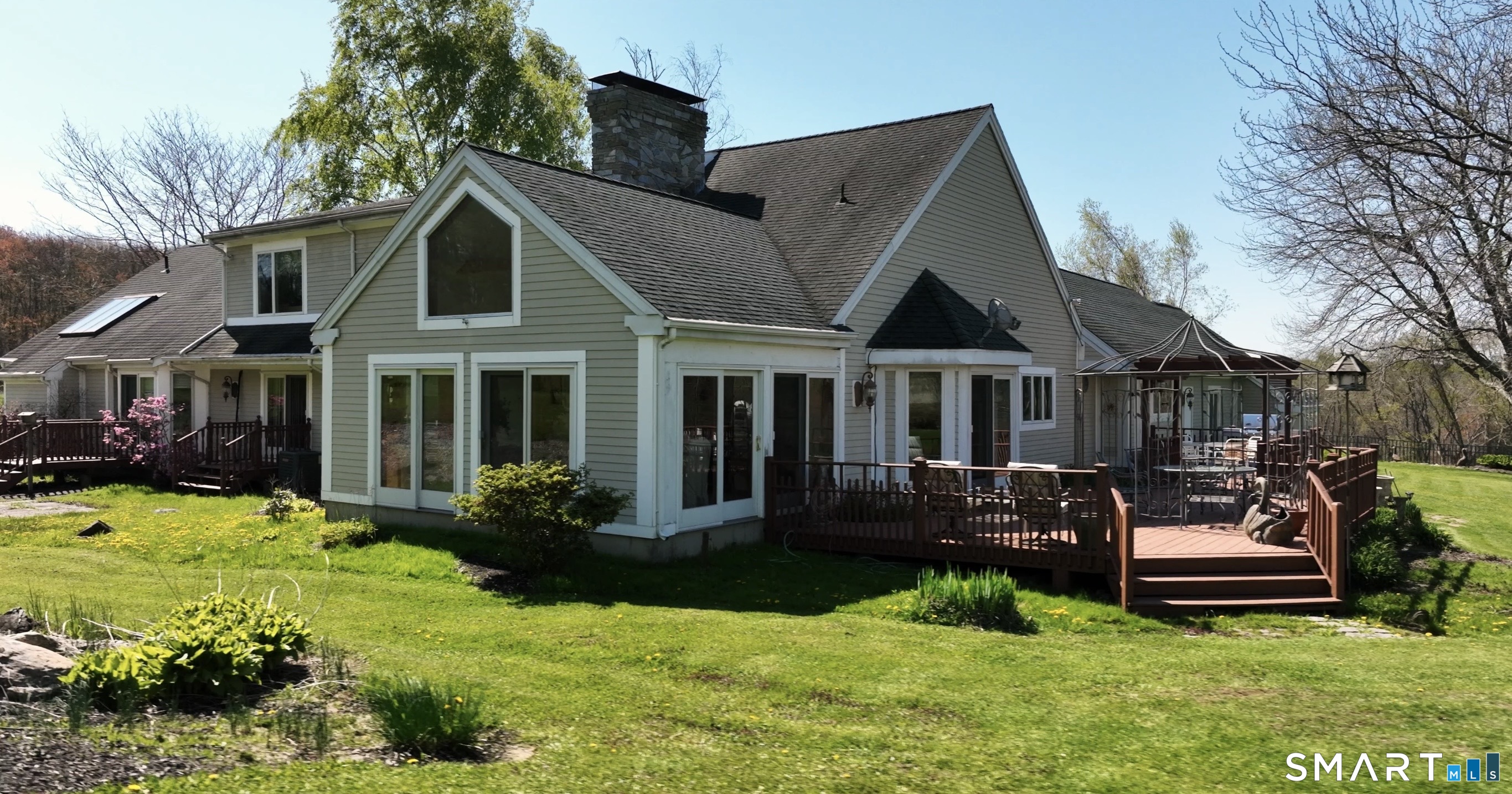 33 Meehan Road Woodstock, CT 06281 - Photo 27 of 39 Rear elevation showcases multiple sliders and the soaring roofline of the four-season sunroom.
