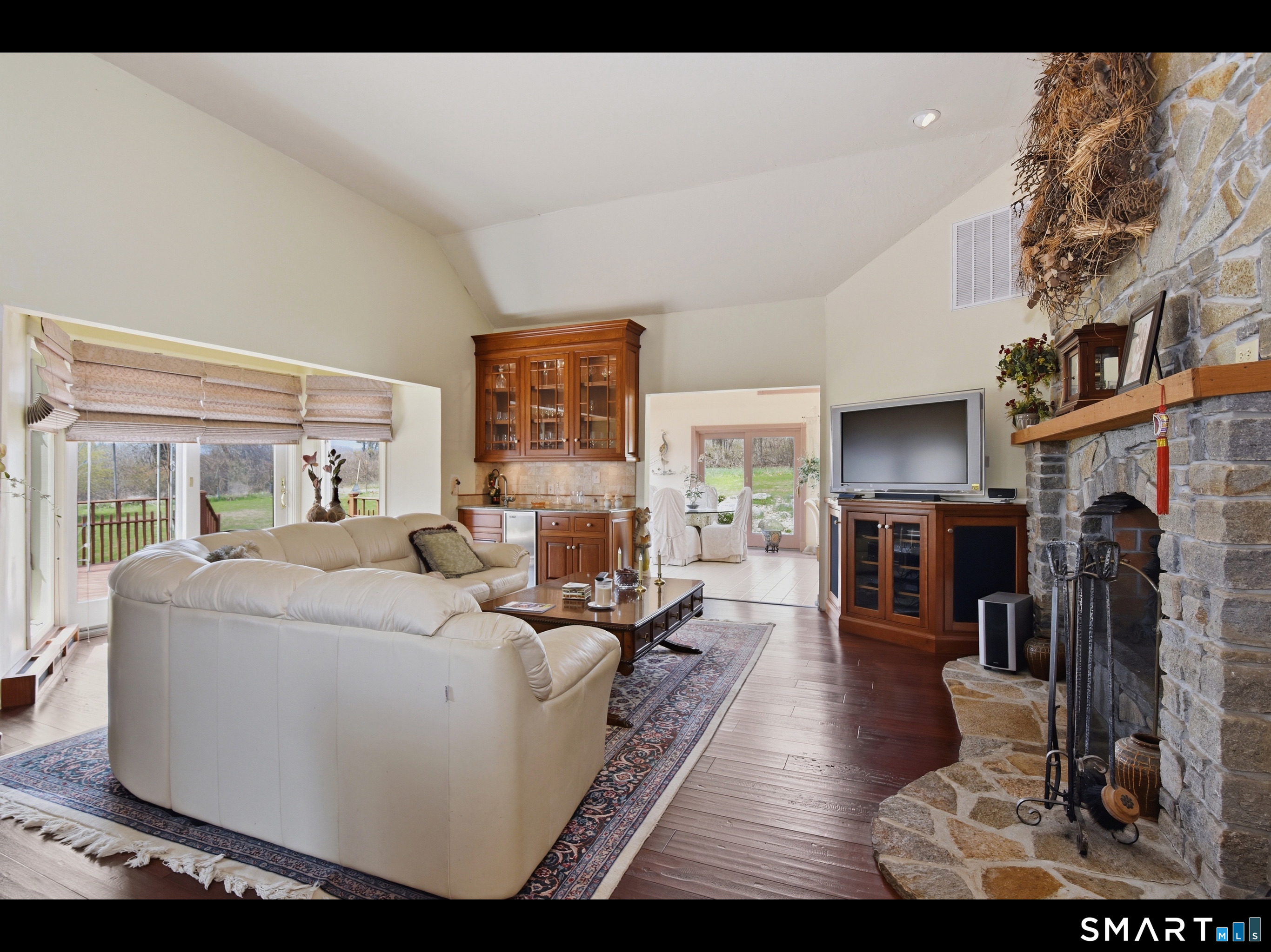33 Meehan Road Woodstock, CT 06281 - Photo 10 of 39 In addition to the dramatic stone fireplace, the family room features a beautiful wet bar, a soaring vaulted ceiling, and a bay-style alcove framing the sliders.