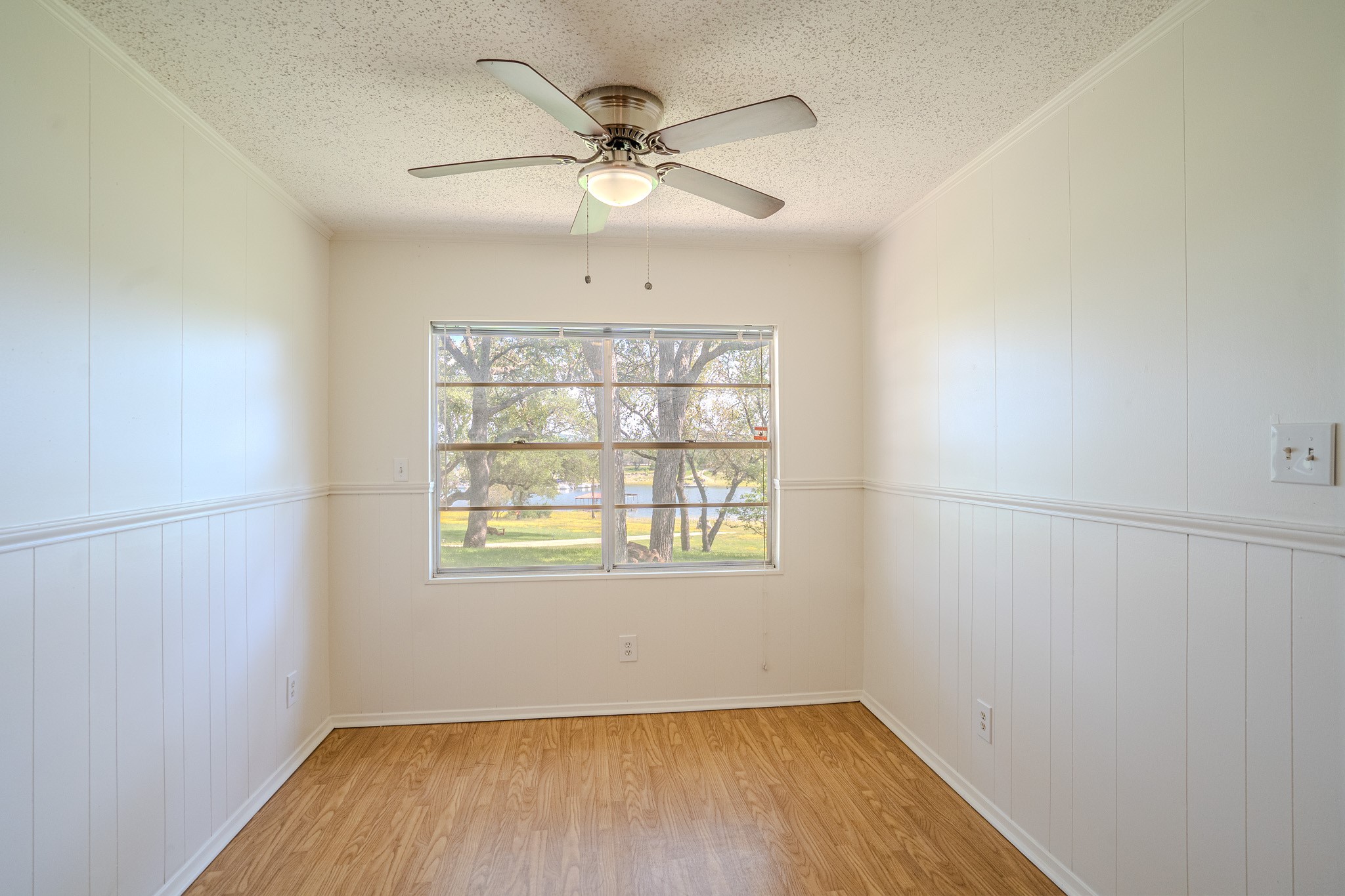 16013 Edwards Drive Austin, TX 78734 - Photo 10 of 18 A quiet room offers a serene view of the surrounding trees and distant water.