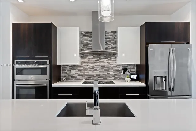 a kitchen with stainless steel appliances kitchen island sink refrigerator and stove