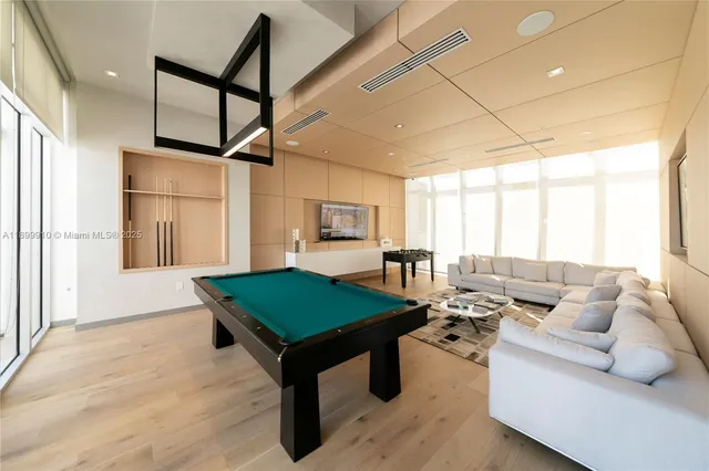 a living room with furniture pool table and a window
