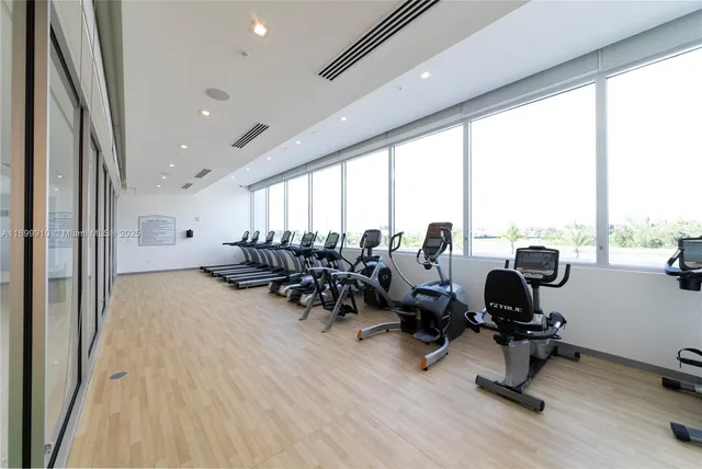 a view of a room with gym equipment and floor to ceiling window