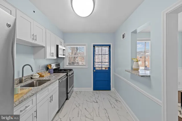 a kitchen with stainless steel appliances granite countertop a sink a stove and a refrigerator