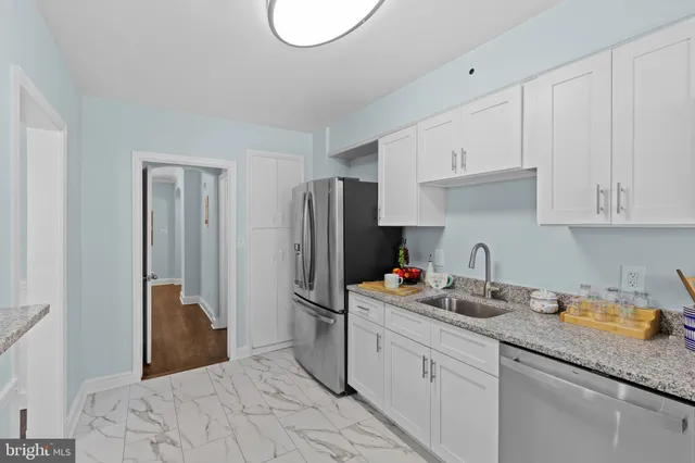 a kitchen with stainless steel appliances granite countertop a refrigerator sink and cabinets