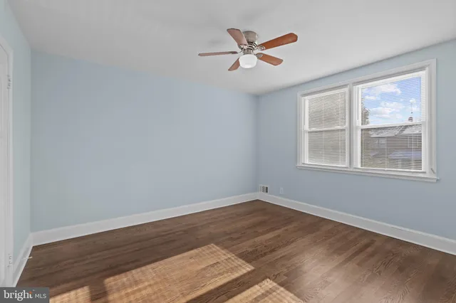 a view of a big room with wooden floor and windows