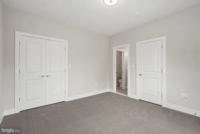 an empty room with windows and closet