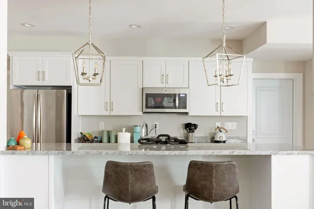 a kitchen with granite countertop white cabinets and stainless steel appliances