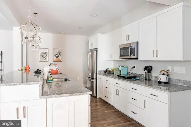 a spacious bathroom with a granite countertop sink a mirror and shower