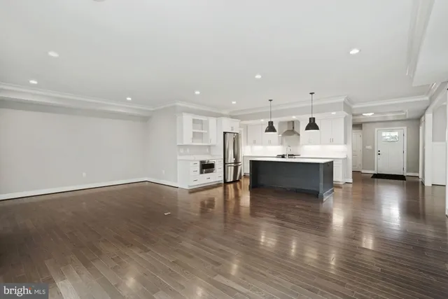 a kitchen that has a sink a stove a refrigerator and a wooden floor