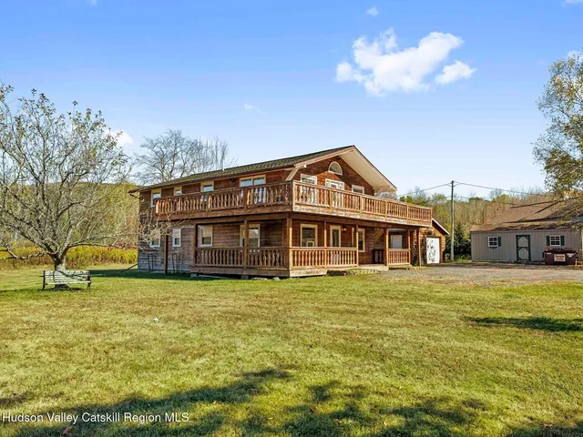 a view of a house with a big yard and large trees