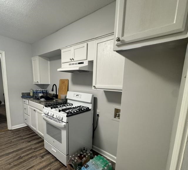 1370 East Alcy Road Memphis, TN 38106 - Photo 5 of 8 Kitchen featuring white cabinetry, dark countertops, a gas range, and a black gooseneck faucet