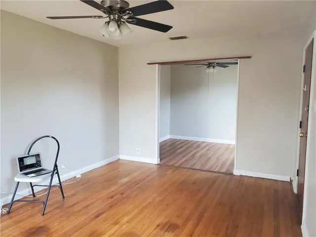a view of a livingroom with wooden floor and a ceiling fan