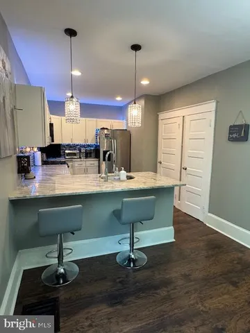 a room with lots of wooden furniture gym equipment and a chandelier