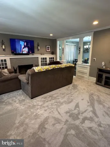 a living room with furniture a bookshelf and a flat screen tv