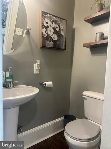 a bathroom with a toilet a sink and mirror