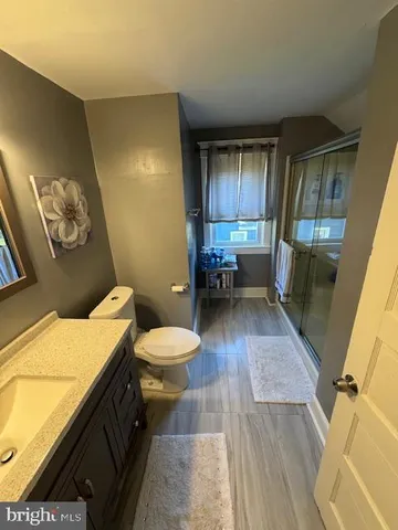 a bathroom with a sink mirror vanity and toilet