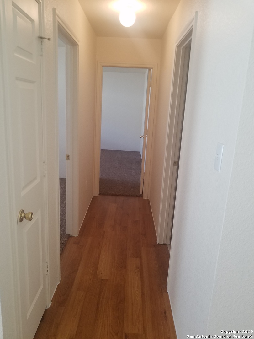 11207 Terra Loop Road San Antonio, TX 78233 - Photo 4 of 7 a view of a room with wooden floor and a hallway