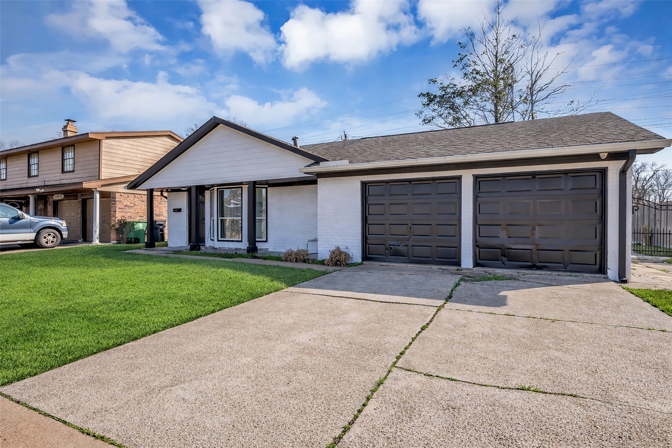 10730 Filey Lane Houston, TX 77013 - Photo 24 of 25 This charming single-story home features a modern exterior with a fresh white and black color scheme. It offers a spacious front lawn, a welcoming covered entry, and a two-car garage. Ideal for those seeking a blend of style and convenience.