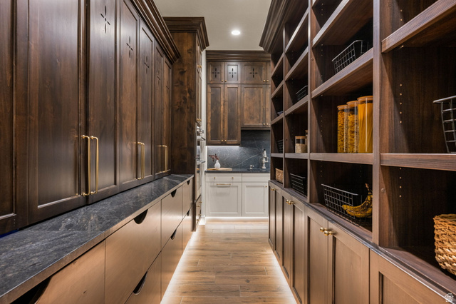 4871 South Homestead Way Washington, UT 84780 - Photo 32 of 151 Bar featuring tasteful backsplash, light wood-style flooring, dark stone counters, dual tone cabinetry, and recessed lighting